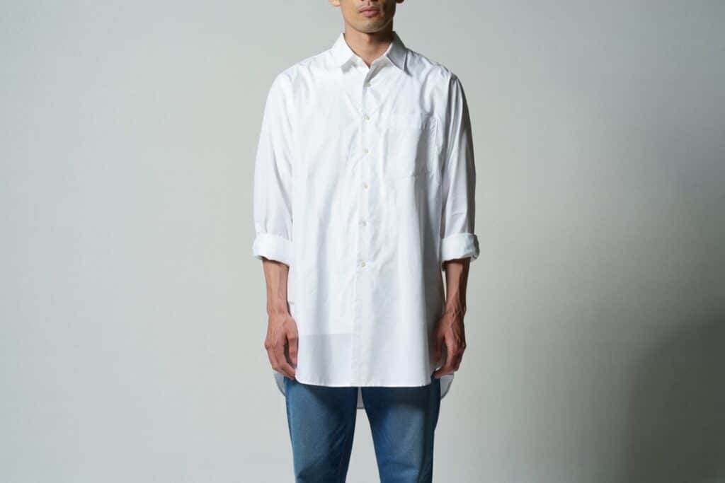 homme portant une  chemise blanche longue avec un jean